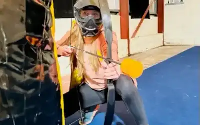 Woman looking at the camera while holding a bow and arrow