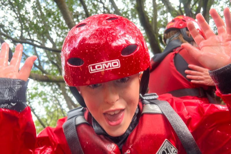 Child in a ghyll scrambling helmet pulling a funny face