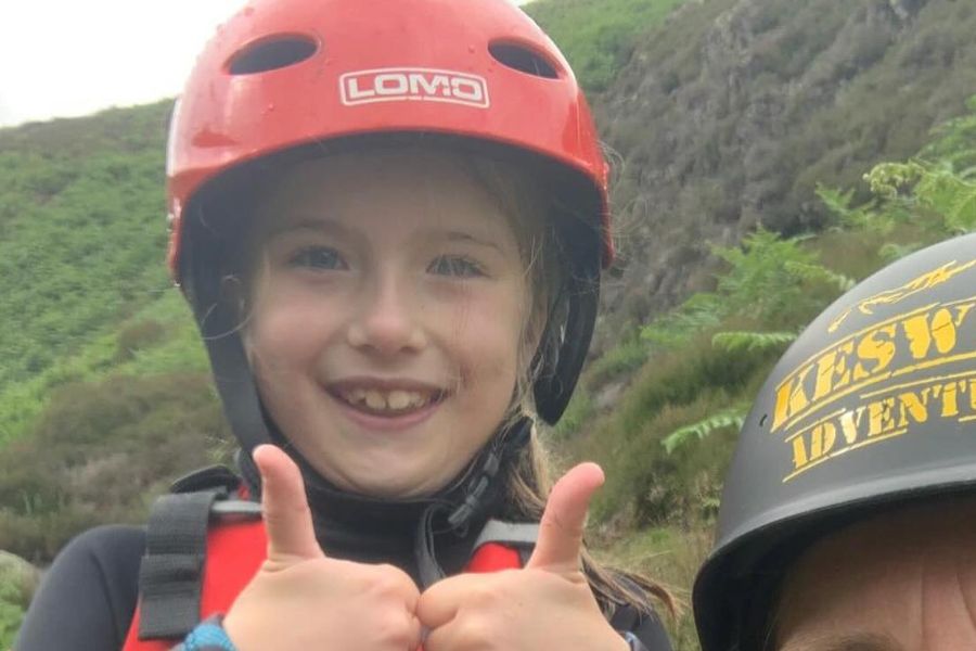 Girl smiling and giving a thumbs up