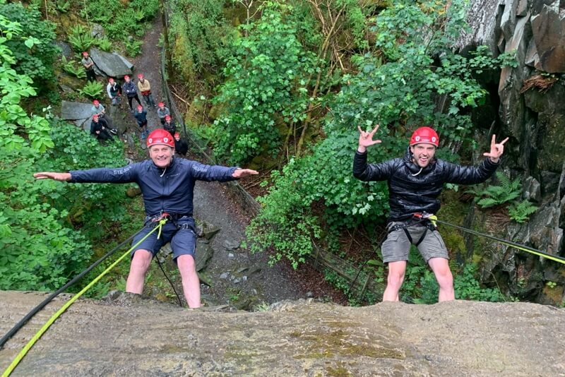 Two men posing during an abseil