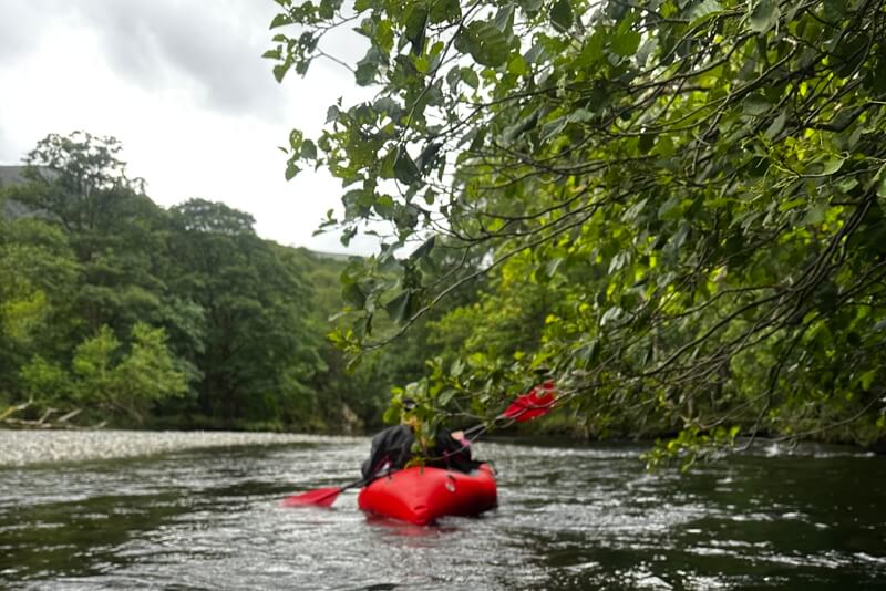 Rear view of woman packrafting