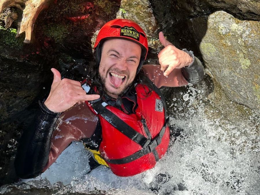Family of ghyll scramblers in front of a waterfall