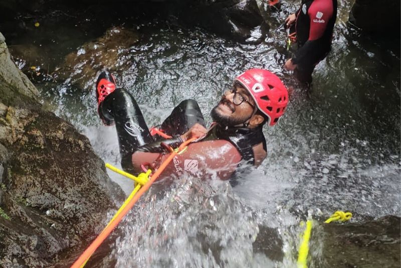 Smiling man abseiling down canyon