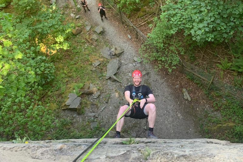 Man abseiling down a steep cliff face