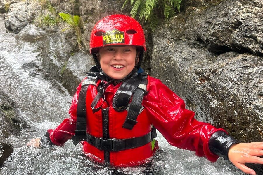 Boy smiling in the water of a ghyll