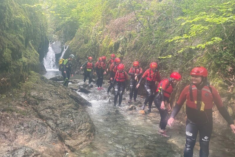 Line of people walking down a river canyon