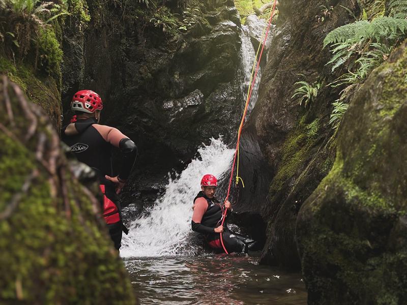 Man abseiling down a canyon waterfall