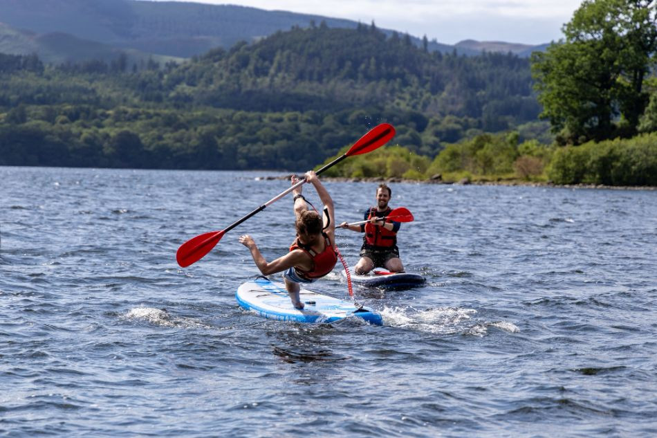 Person falling off a paddle board on Derwentwater