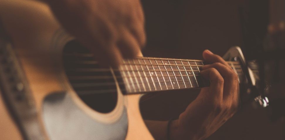 Person playing an acoustic guitar