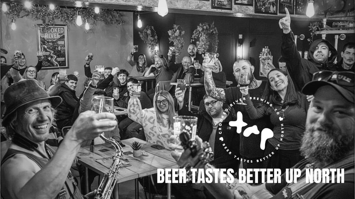 Group of people raising their classes in the Crooked River Tap bar