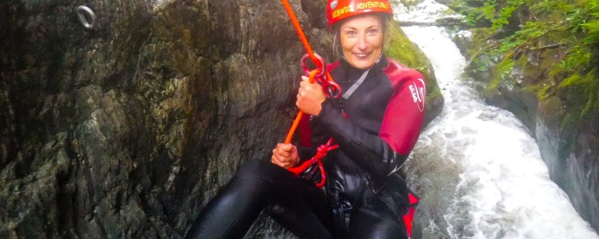 Smiling woman abseiling into a ghyll