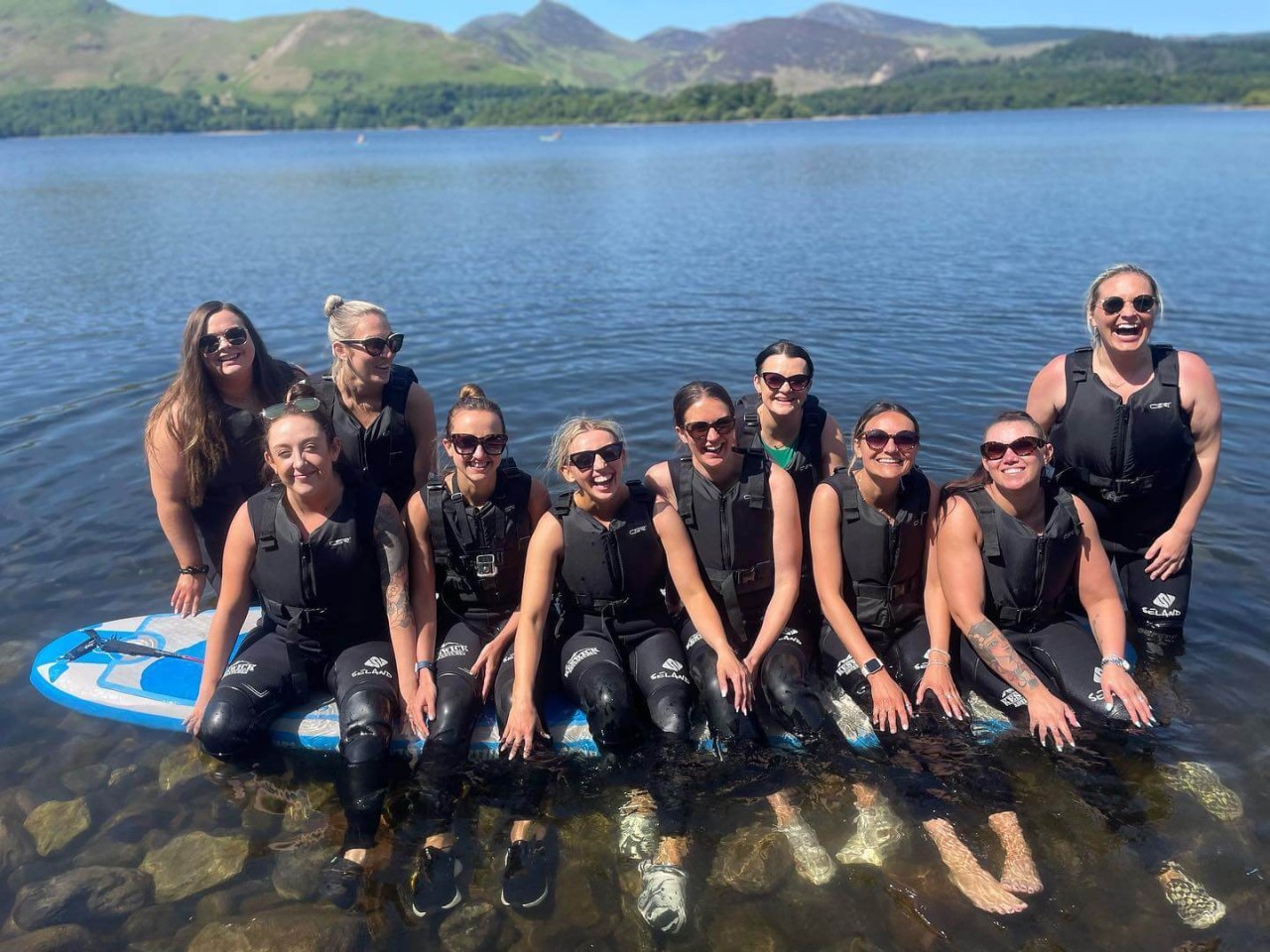 Group of hen do ladies sitting on a paddleboard on Derwentwater